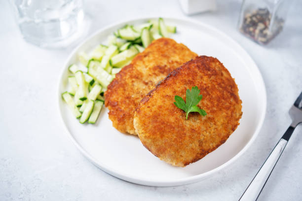 istock Fresh prepared schnitzel in a plate with fresh cucumber slices 1424372929