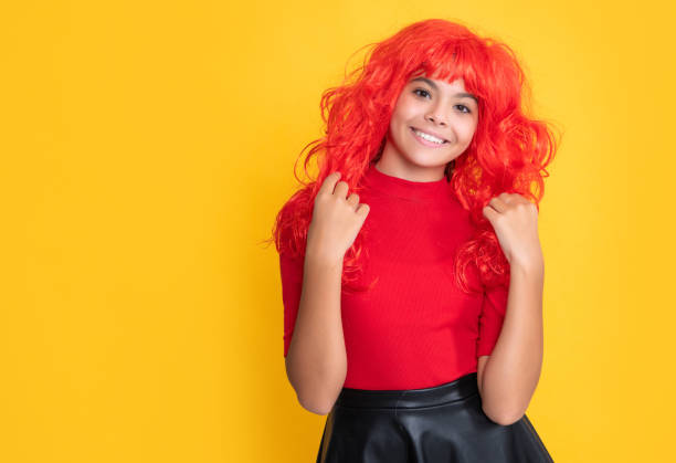 istock child smile with red long hair on yellow background 1424373996