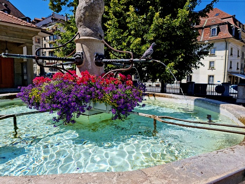 A fountain with crystal clear drinking water decorated wit flowers.