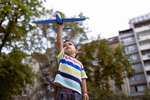 Little boy playing with a airplane toy