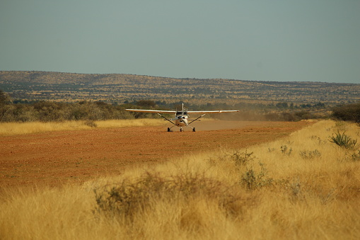 Small Cessna airplane landing on rural Namibian airstrip