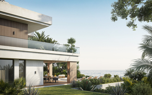 Computer generated image of large house along the sea. Modern villa with two floors in the middle of a garden overlooking the sea in 3d.