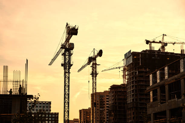 istock Cranes at yellow sunset and buildings at construction site 1424398461