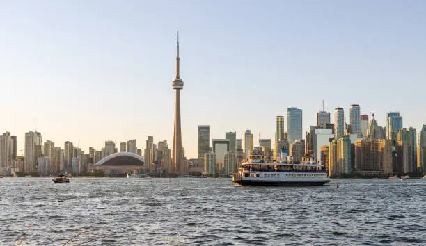 Toronto City downtown skyline at sunset time. Toronto Island Ferry on inner Harbour. Ontario, Canada.