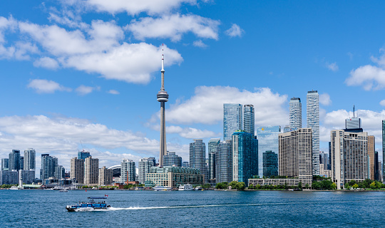 Toronto, Ontario, Canada - July 30 2021 : Toronto City downtown skyline. Water taxi on Toronto Harbour.
