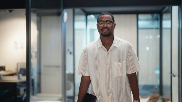 istock Black ethnic businessman walking in office corridor in modern office working space 1424404669