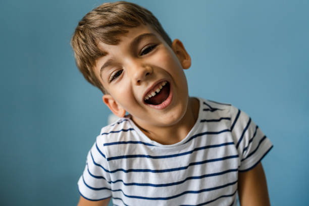 istock One caucasian boy child in front off blue wall portrait goofing around 1424408549