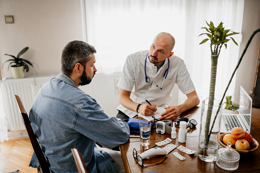 he doctor explains to the patient at home