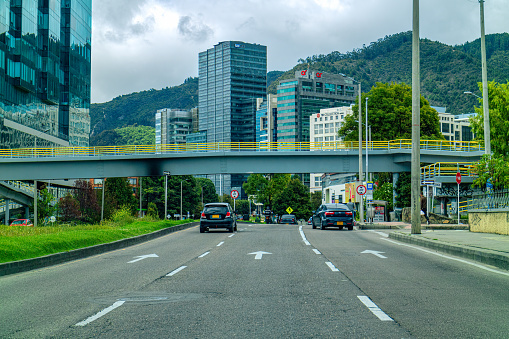 Bogota, Colombia - June 27, 2020: This is the Northbound carriageway of the usually busy Carrera 9 or 9th Avenue, in the Colombian Capital city of Bogota. Driver's Point of View. The altitude at street level is 8,660 feet above mean sea level. Background: Andes Mountains. Horizontal Format.