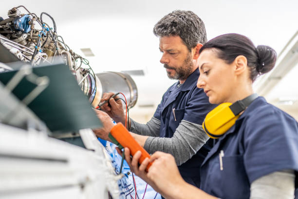 istock Male and female aviation engineers working with voltage tester, side view 1424424642