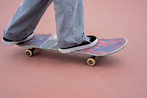 Young latina millennial girl riding a skateboard in a skatepark in the urban environment of the city of bogota. Lifestyle and skateboarding tricks.