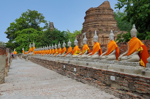 Ayutthaya, Thailand- April, 30 2016: This is Wat Yai Chaimongkol in Ayutthaya, Thailand.There are many Buddhas. They wear bright orange robes. This temple was built in 1357 during the Ayutthaya period. The 72m high pagoda is especially famous. The temple is a very old place.