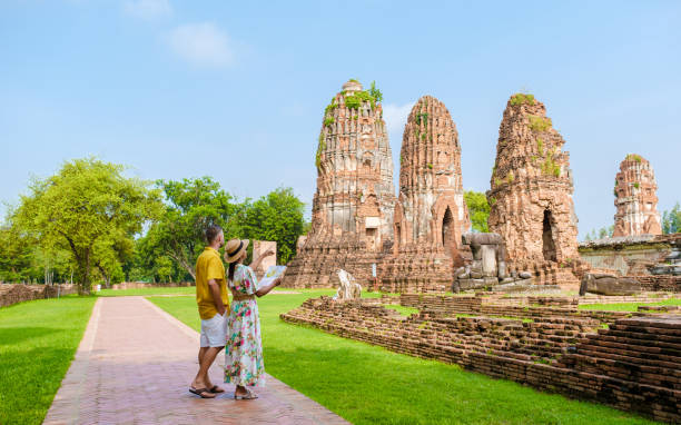 ayutthaya, thaïlande à wat mahathat, couple d’hommes et de femmes avec un chapeau et une carte touristique visitant ayyuthaya thaïlande - buddha ancient asia asian culture photos et images de collection