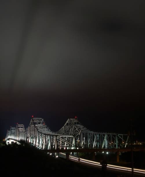 Natchez-Vidalia bridge at night with light reflections off low cloud cover above.  High angle view.
