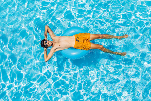 istock Young man swims in the pool, summer vacation concept 1424440911