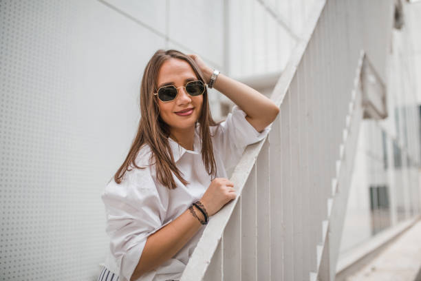istock A smiling woman stands leaning on a fence 1424443900