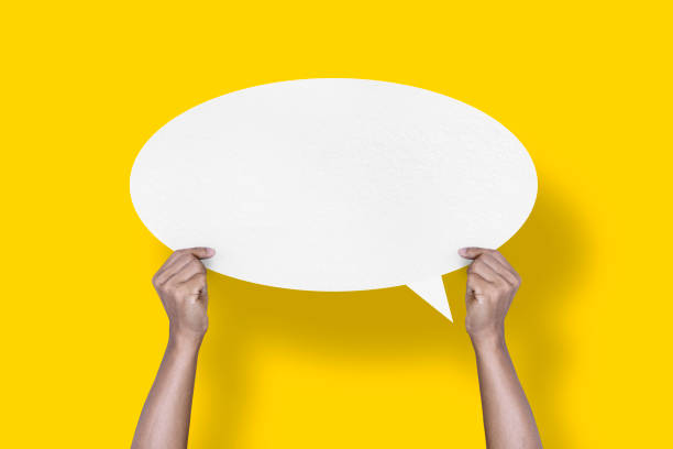 istock hand holding round white paper balloons speech bubbles isolated on yellow background 1424444608