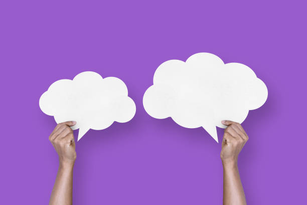 istock hand holding white paper cloud shape speech bubble balloon isolated on purple background communication bubbles 1424444638