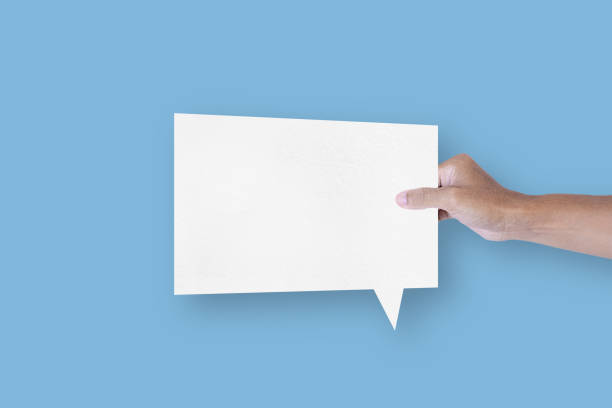 istock Hand holding a square shaped white paper bubble speech bubble isolated on light blue background. communication bubbles 1424445158