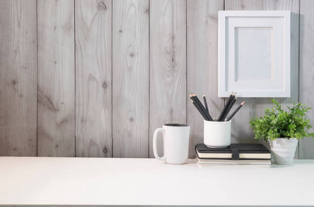 istock Blank picture frame, pencil holder, notebook and coffee cup on white table. 1424458998