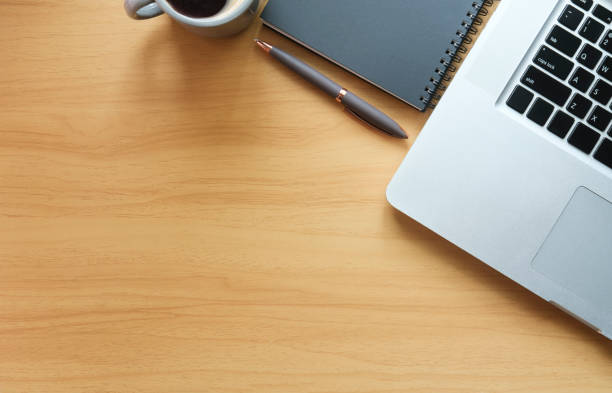 istock Top view laptop computer, notebook and coffee cup on wooden table. Copy space for your text. 1424459011