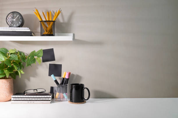 istock Creative workplace with supplies, house plant and coffee cup on white table. Copy space for your advertise text. 1424459095