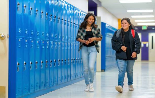istock Best friends walking thru school corridor 1424466007