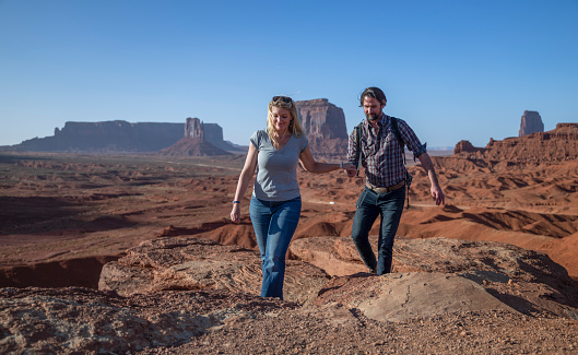 Couple walking during sunset in Monument Valley park, Utah