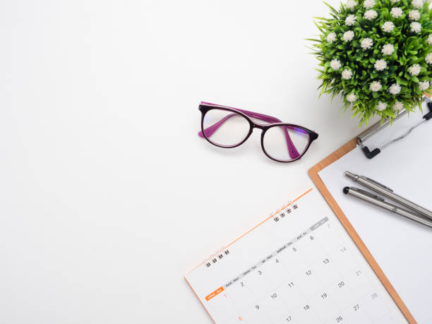 istock Close up pen on document poard and glasses calendar top view copy space 1424479718