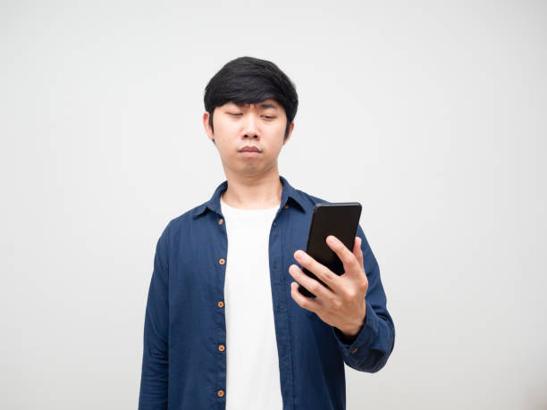 istock Young man try to looking at mobile in his hand eyes problem 1424479827