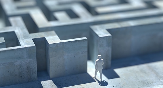 Business standing in front of a maze entrance, uncertainty, unsure, fear, leader, leadership