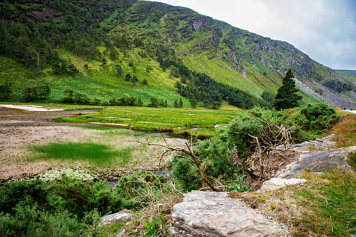 Idyllic view in Glendalough Valley, County Wicklow, Ireland. Mountains, lake and tourists walking paths.