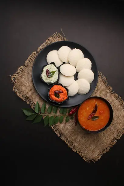 Photo of Idly sambar or Idli with Sambhar and green, red chutney. Popular South indian breakfast