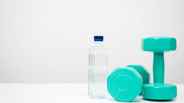 istock Dumbbell with water bottle on the table white background copy space 1424500362