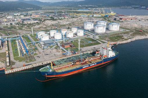 Nakhodka, Russia - July 31, 2022: The top view on Oil-storage tank with the tanker at a mooring.