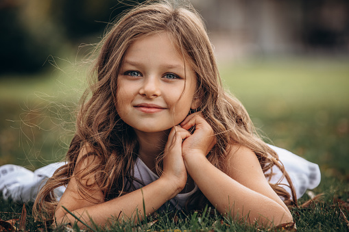 In Western Colorado Young Female Child Standing Outdoors Among Trees on a sunny Fall Day Looking into the Distance; Part of a Series (Shot with Canon 5DS 50.6mp photos professionally retouched - Lightroom / Photoshop - original size 5792 x 8688 downsampled as needed for clarity and select focus used for dramatic effect)