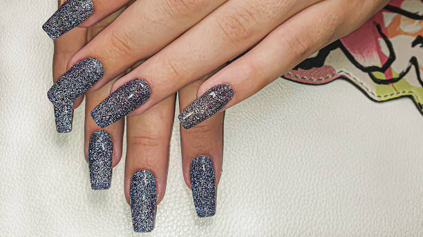 istock Acrylic nail extension, manicure, nail correction, hands in the foreground. Reflective design. 1424507099