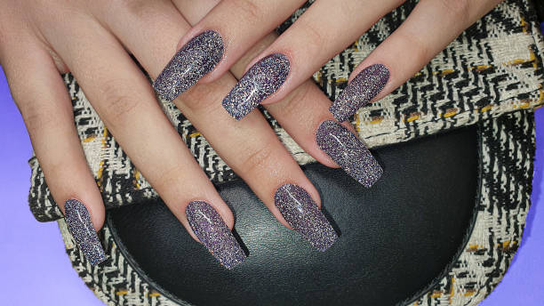 istock Acrylic nail extension, manicure, nail correction, hands in the foreground. Reflective design. 1424507101