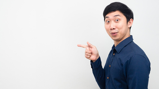 Asian man excited and point finger at copy space white background