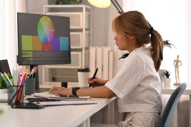 istock Side view young woman working with color palette, choosing color samples for design project at graphic studio. 1424508571