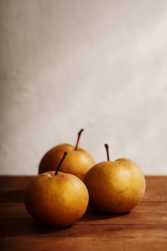 Three asian pears on rustic wooden table