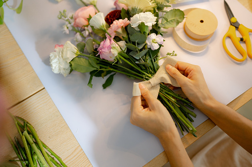 Businesswoman florist arranging bouquet in her flower shop.