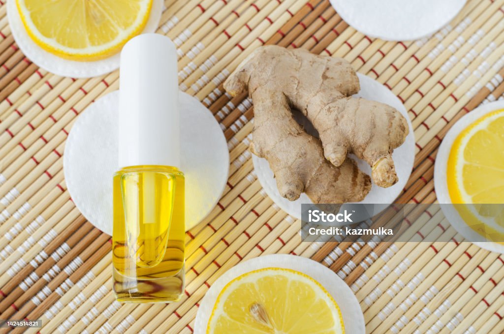 Small bottle with essential ginger oil (extract, tincture, infusion, perfume) and lemon extract. Aromatherapy, spa and herbal medicine ingredients. Copy space Alternative Lifestyle Stock Photo