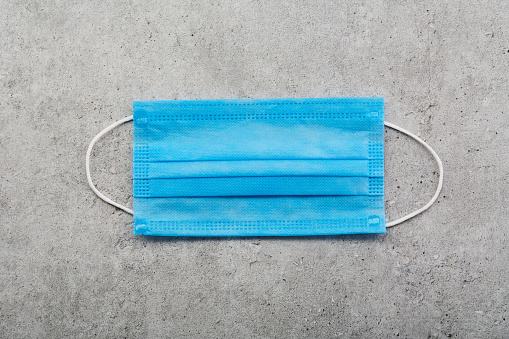 Doctors surgical protective face masks lying on grey background