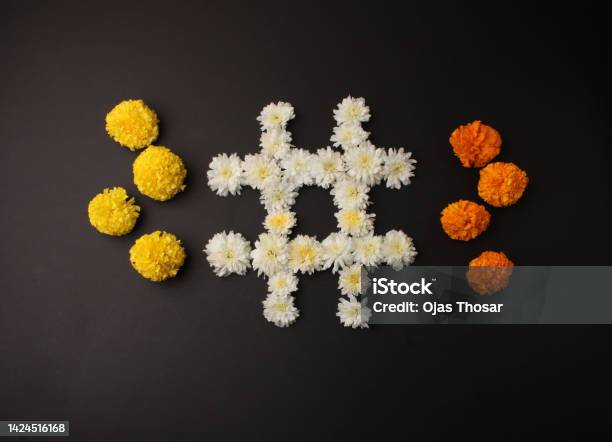 Flower Rangoli For Diwali Or Pongal Festival Made Using Marigold Or Zendu Flowers And Clay Oil Lamp Over Black Background In Tick Tack Toe Game Stock Photo - Download Image Now