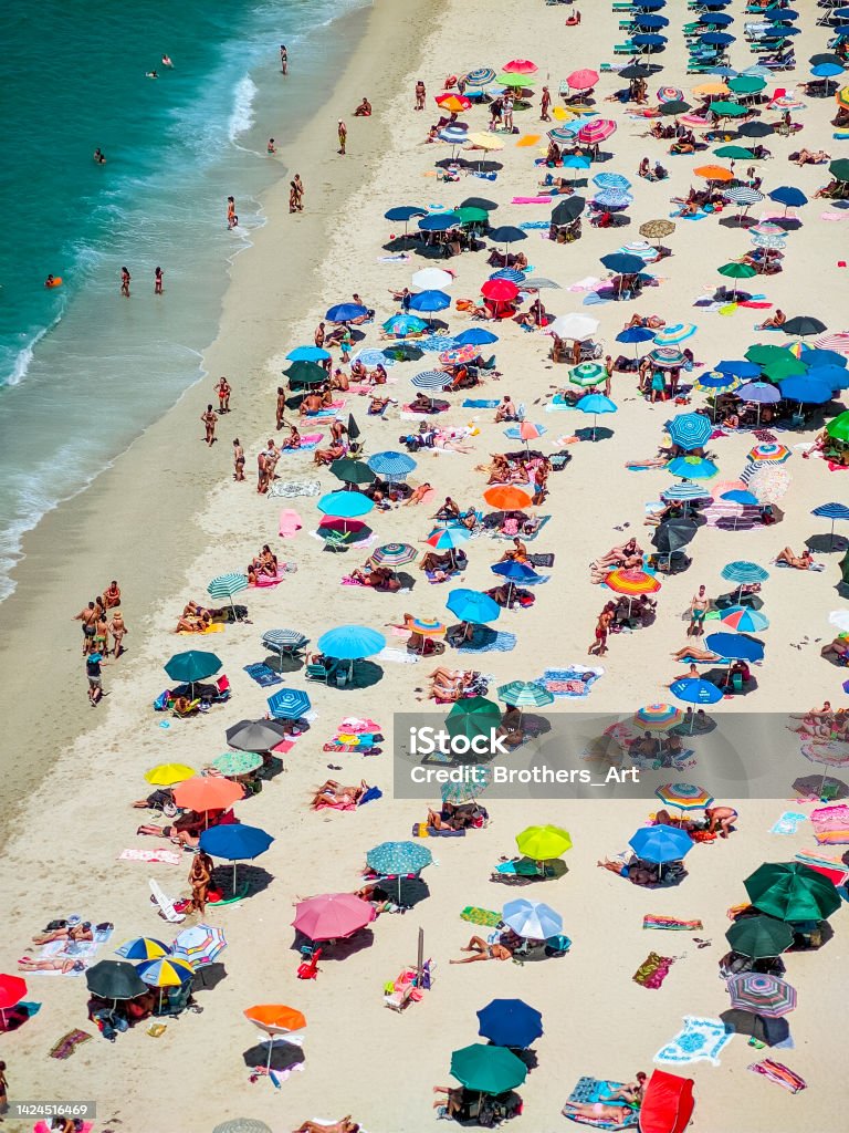 tourists on the beach in tropea Italian beaches of Calabria seen from above, tourists seen rest under colorful umbrellas, travel reportage in Tropea Town Aerial View Stock Photo