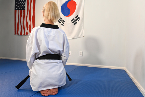 Martial artist kneeling in her gym.