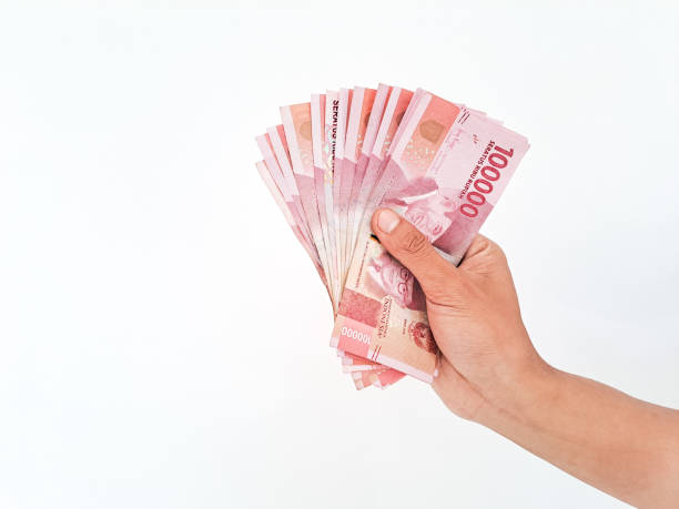 Man's Hand holding rupiah money isolated on white background