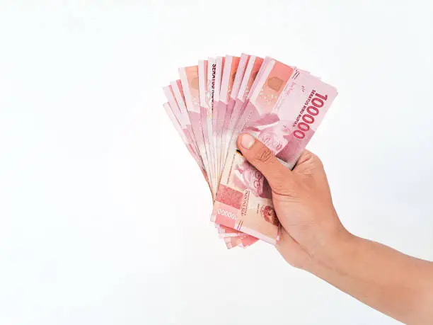 Photo of Man's Hand holding rupiah money isolated on white background