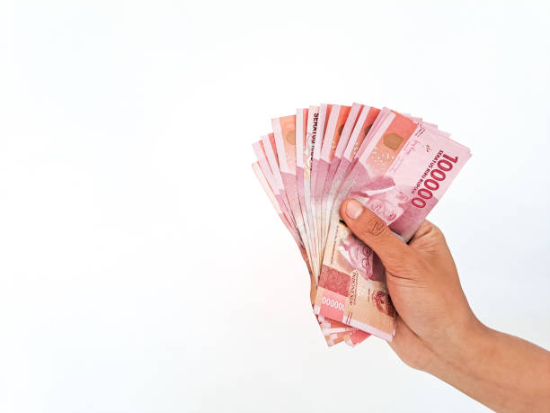 istock Man's Hand holding rupiah money isolated on white background 1424519761